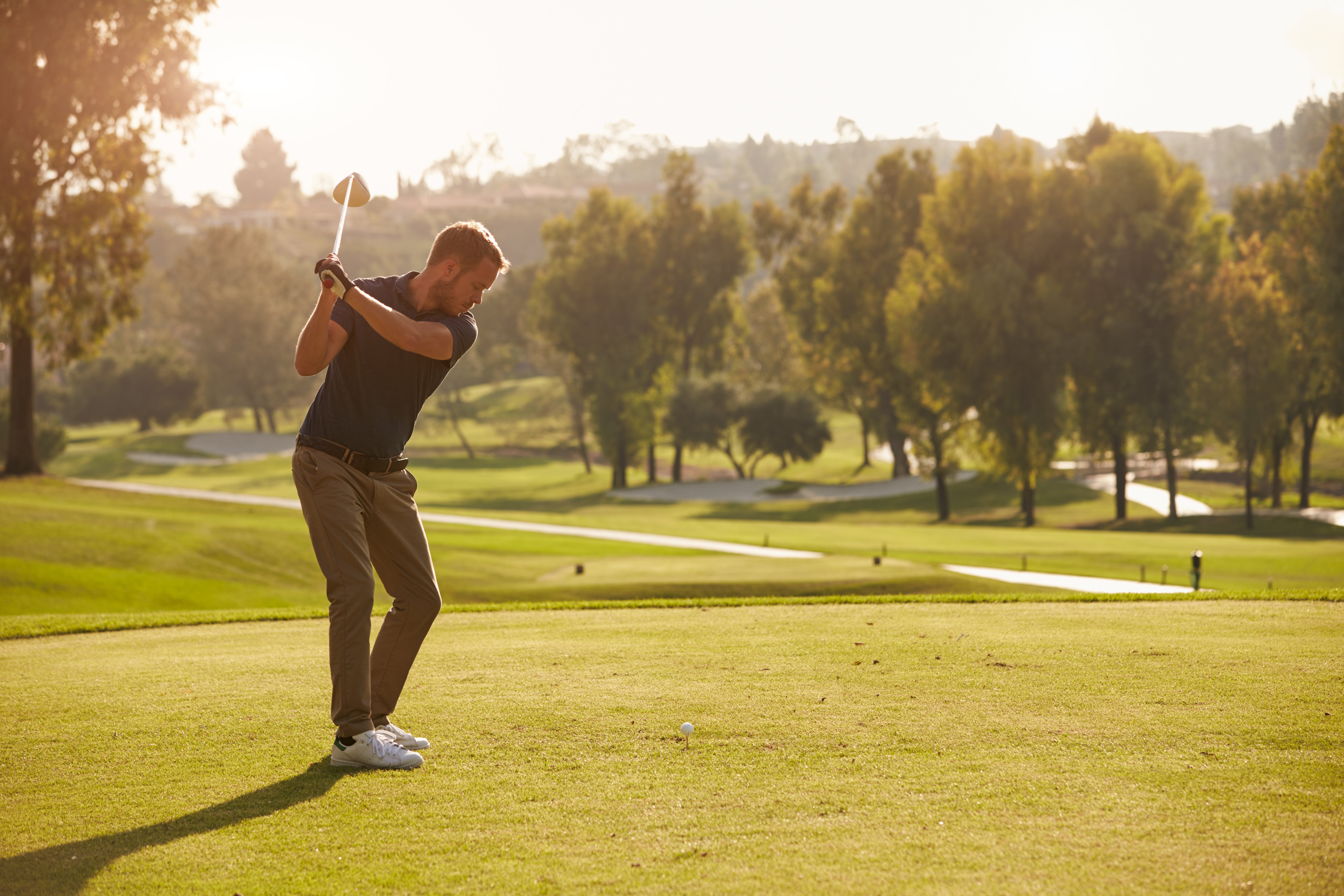 Man taking golf swing on golf course