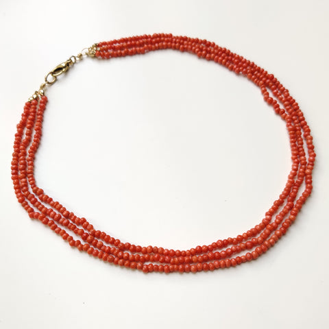 Side overview of the finished three-strand coral necklace. 