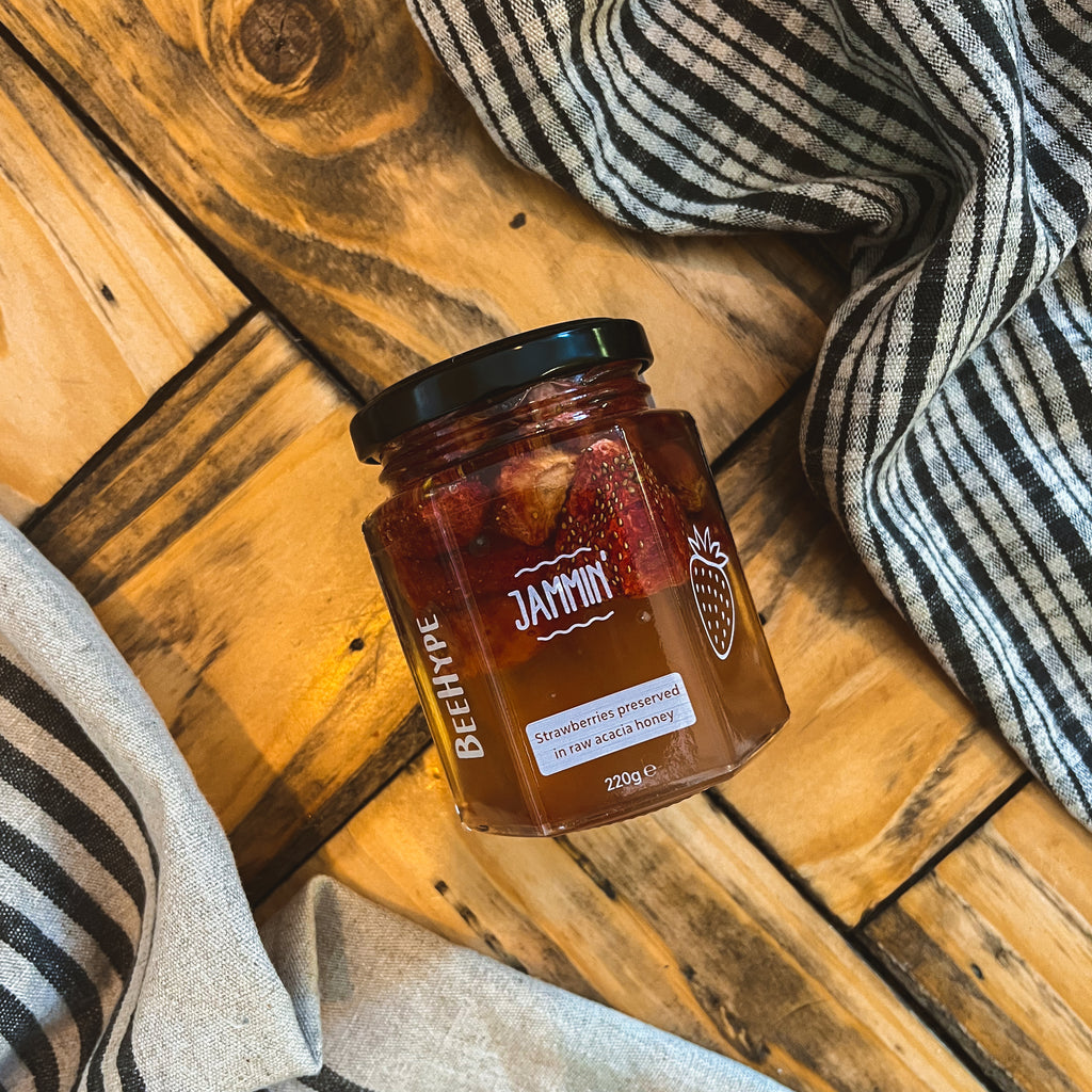 Healthy mix of natural honey with different nuts in a jar on white