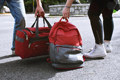 two people grabbing their travel bags