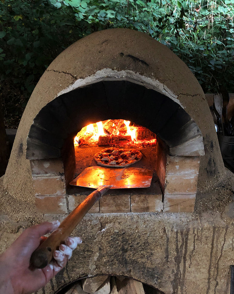 Wood fired Pizza oven cooking our homemade pizza