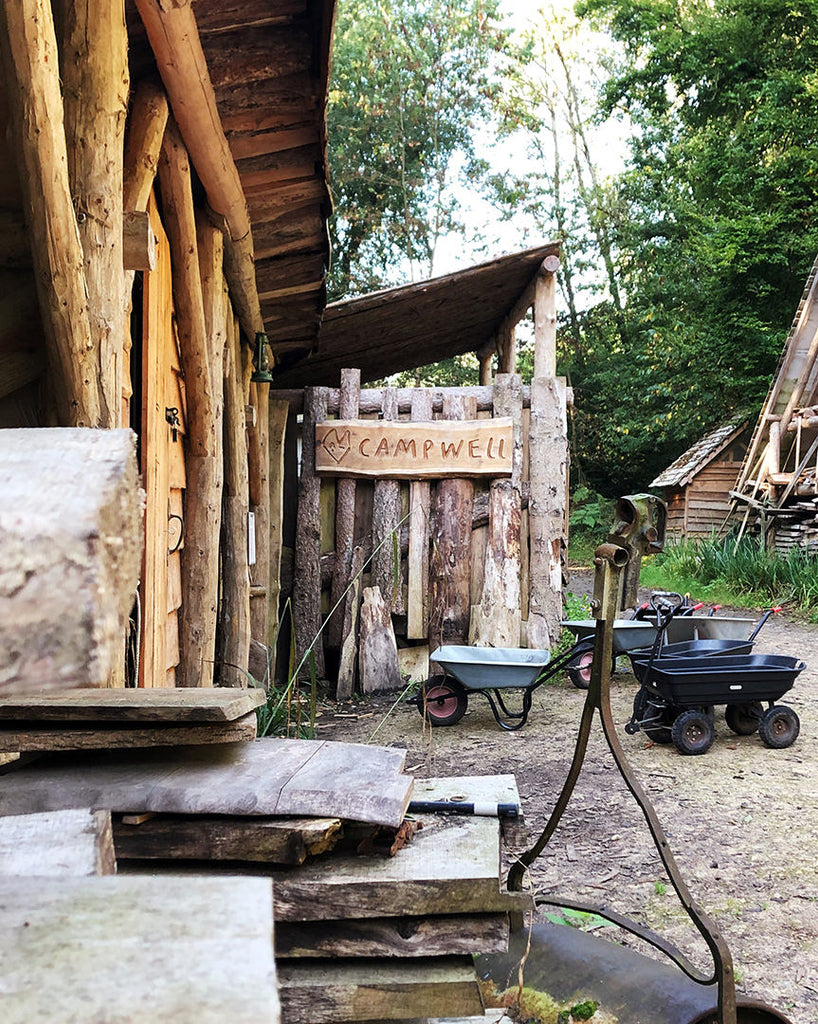 Camp Well entrace in forest with trailers for carrying bags