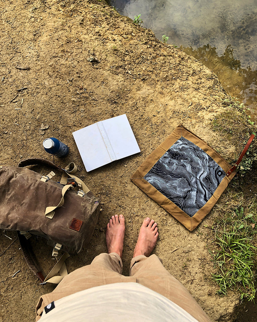 Time to relax, looking down at bag, book and rug