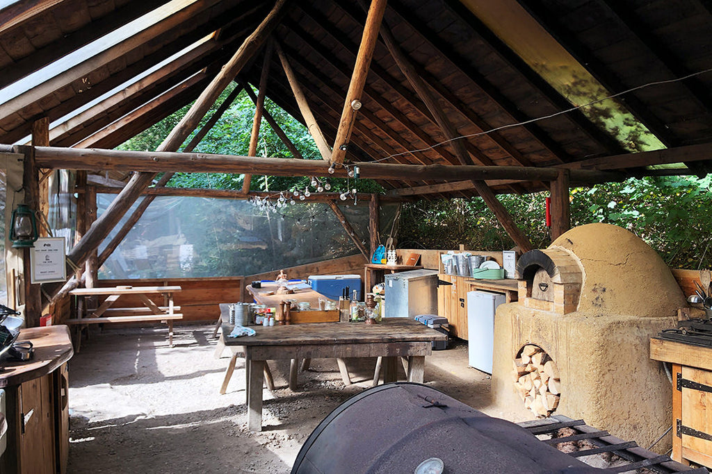 Wide angle shot of village kitchen with table and pizza oven