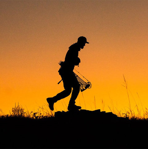 Sitka Gear - Man Running On Ridge with compound bow wearing core lightweight hoody hunting gear