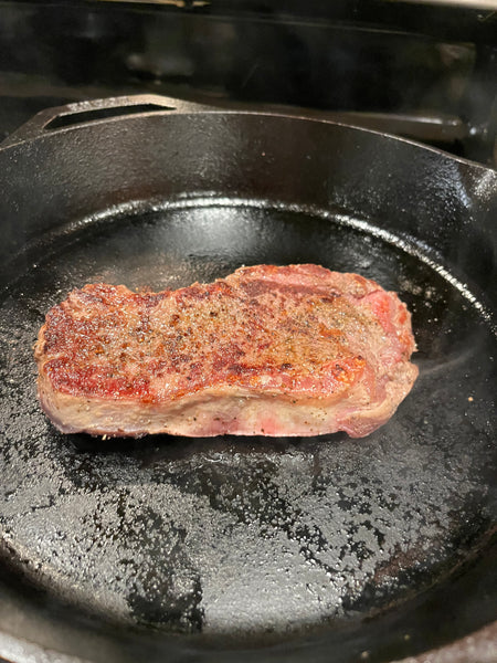 Bison ribeye steak cooked on one side 