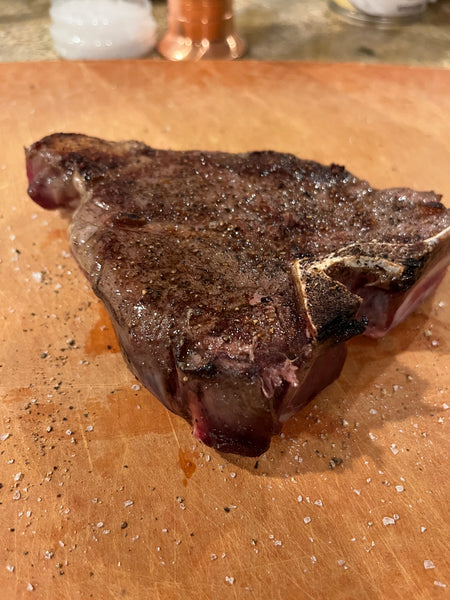 Browned elk porterhouse steak on a cutting board