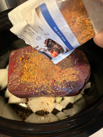 Sprinkling Sunday Pot Roast mix on an Angus Chuck Roast