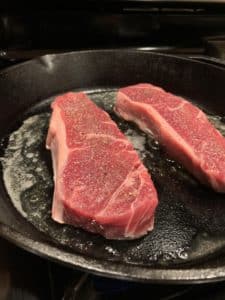 Steaks cooking in pan