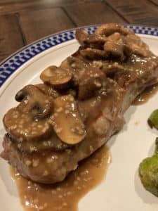 New York Strip with mushroom sauce on a plate