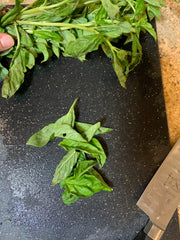 Basil on a cutting board with a knife