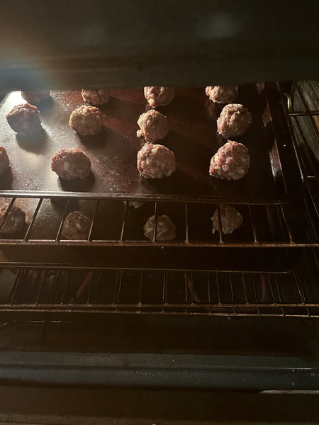 Meatballs cooking in an oven