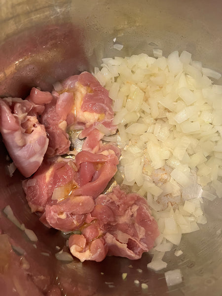 Chicken browning in an Instant Pot with onions