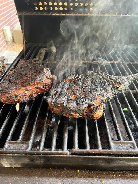 Bison tomahawk steaks cooking on the grill