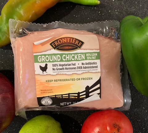 A package of ground chicken nestled among vegetables