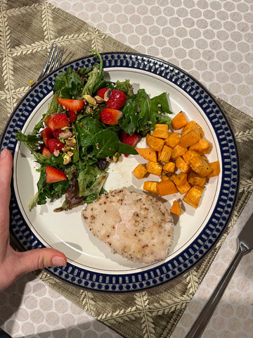 Plated marinated chicken with sweet potatoes and green salad