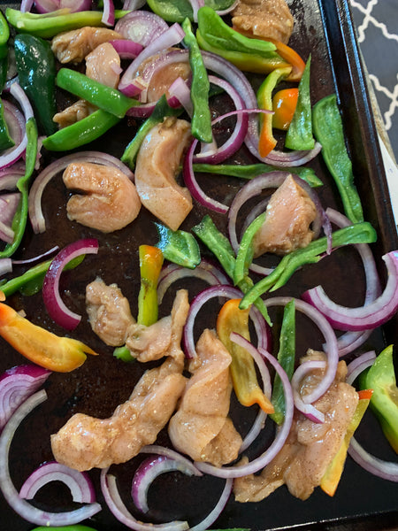 chicken on a sheet pan with peppers and onions