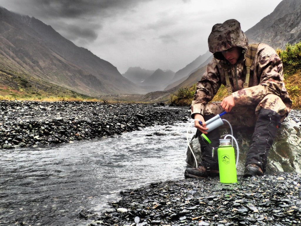 Alaska Man Filling Explorer Bottle from a Creek