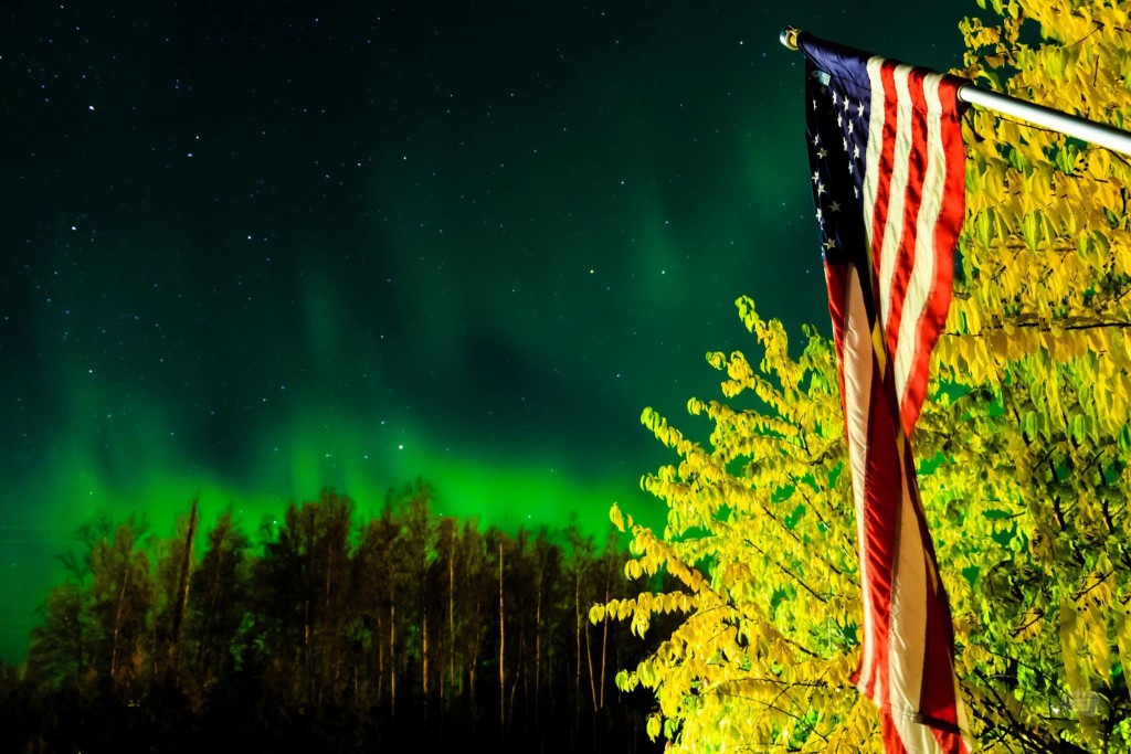 American Flag under the Aurora Borealis.