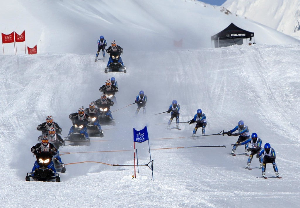 A sequence shows a snowmachine driver sling-shotting a skier toward First Aid after their 2 1/2-mile uphill run. (Photo by Brian Montalbo)