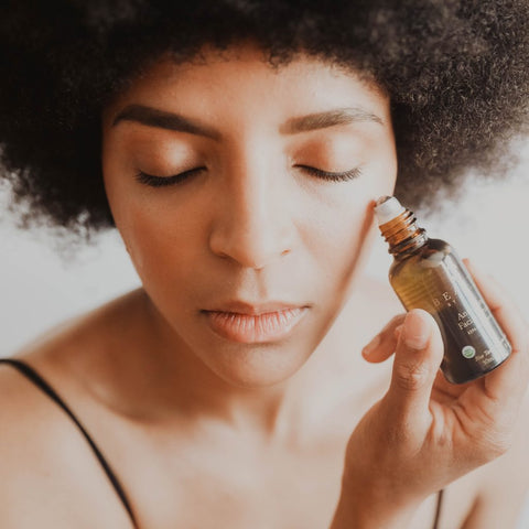 Image of a woman applying some of BBE's anti-aging facial serum.