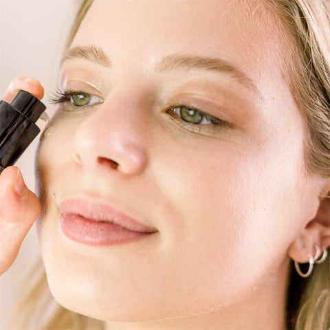 Woman applying bakuchiol serum to her cheek