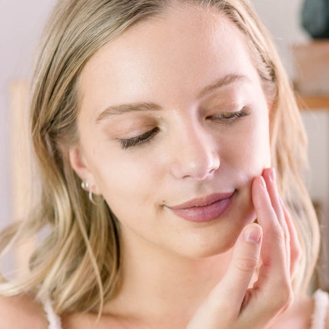 Woman rubbing bakuchiol serum into her face