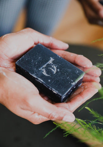 Hands holding beauty by earth's charcoal face bar