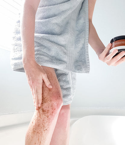 Image of a woman using the BBE coffee and sugar scrub on her legs