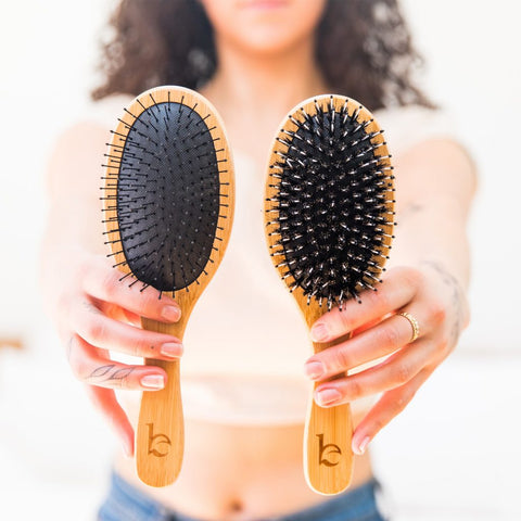 Image of a woman holding up two BBE hair brushes.