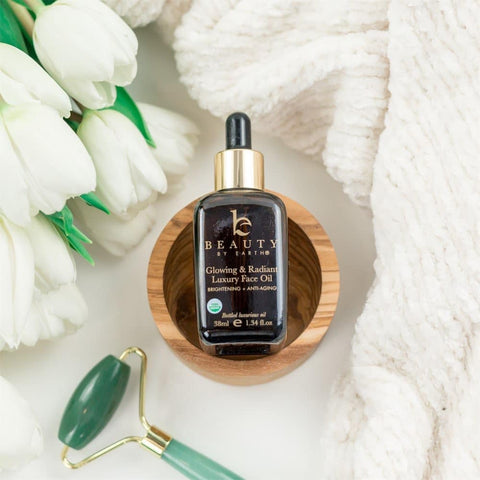 Image of the BBE glowing & radiant facial oil, alongside a jade roller. 
