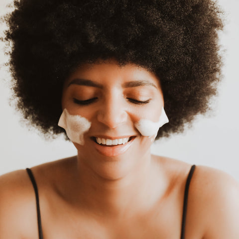 Image of a woman using the BBE foaming cleanser to wash her face.