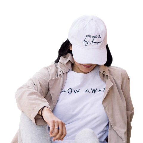 Image of the new BBE merch, including the Glow Away t-shirt and the Ran out of Dry Shampoo baseball hat - total beauty must-haves.