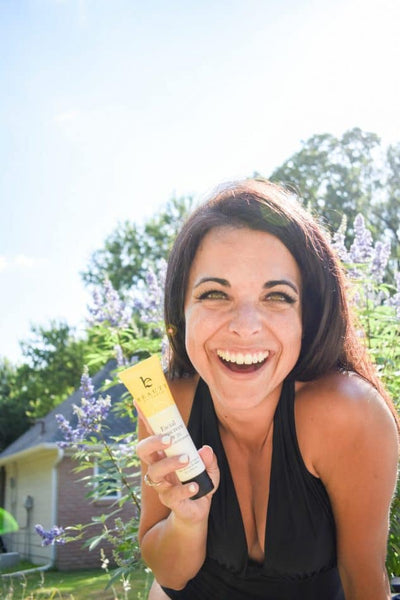 Image of a happy BBE girl holding up her favorite sunscreen. 