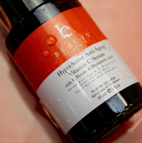 Image of a hand holding up the BBE HyperActive Anti-Aging Vitamin C serum.