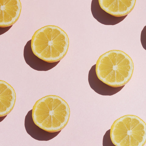 Sliced lemons on a pink background