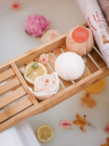 Image of a bath tray with a BBE bath bomb on it.