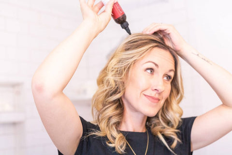 Image of a woman using the BBE natural dry shampoo.