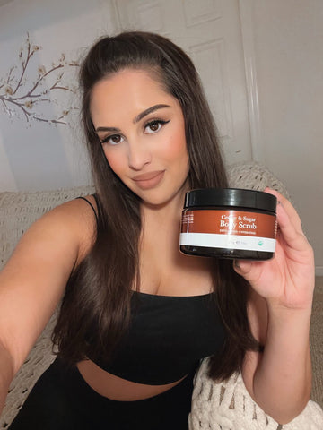 Image of a happy customer holding the BBE coffee & sugar body scrub 