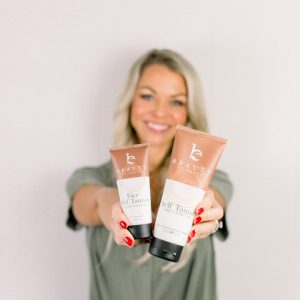 Woman holding Beauty By Earth's Self Tanning Lotion 