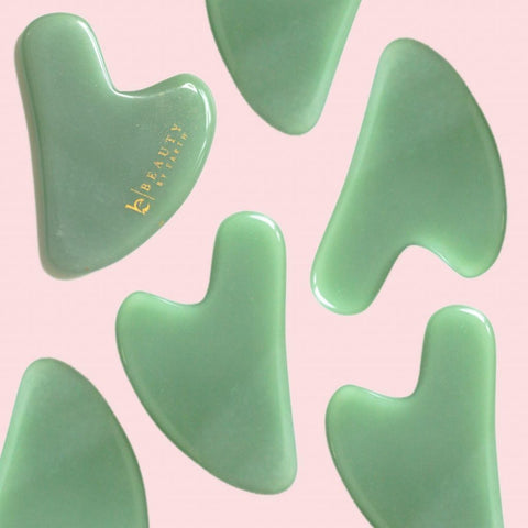 Multiple Beauty by Earth Jade gua sha's on a pink background