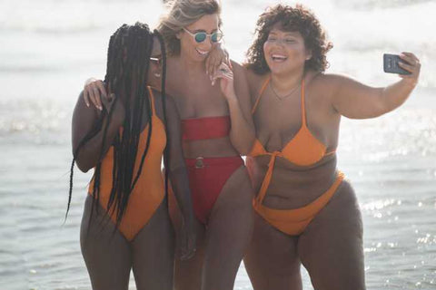 A group of woman taking a selfie together on the beach