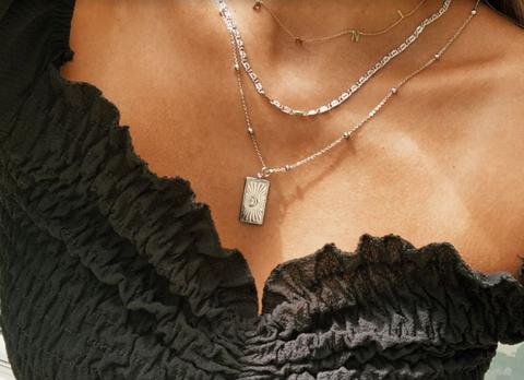 Image of a woman wearing XIO by Ylette necklaces, a Latino owned brand.