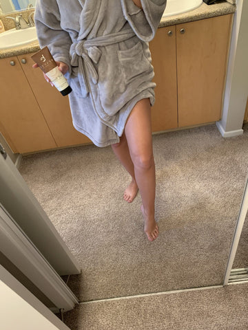 Image of the same previous BBE customer in her comfy robe, showing off her after results of dark tanned legs.