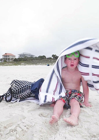 child under towel sunburned