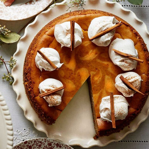 Image of a pumpkin pie with whipped cream dollops on top of it.