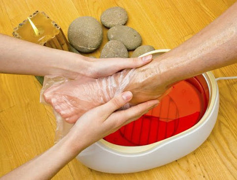 Image of feet inside of a paraffin wax bath as part of cold weather beauty rituals 