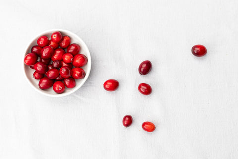 Cranberries in a bowl on a white background