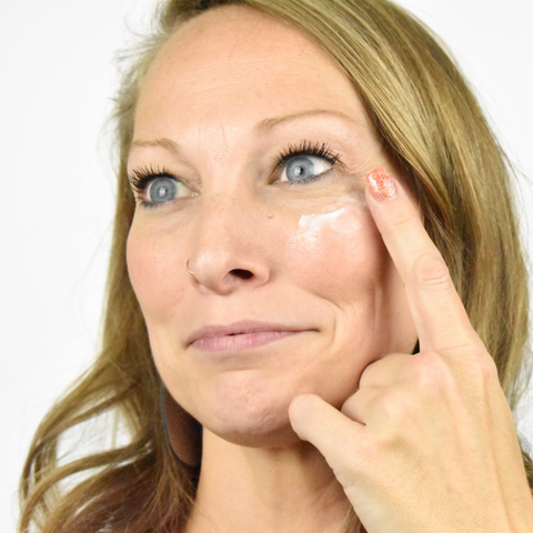 Girl applying cream on her face