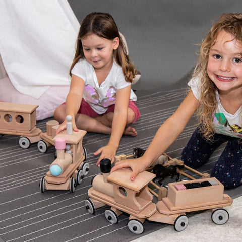 Zwei Mädchen spielen mit dem Holzzug Lotte und seinen verschiedenen Anhängern - Lorre und Personenwagen